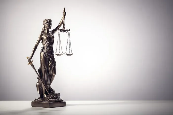 legal and law concept statue of lady justice with scales of justice background
