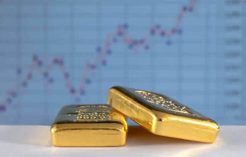 gold bullions on the background of the growth chart selective focus