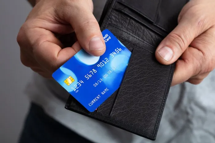 selective focus of a person's removing credit card from wallet