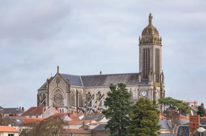a picture of the saint peter church towering the nearby houses of cholet