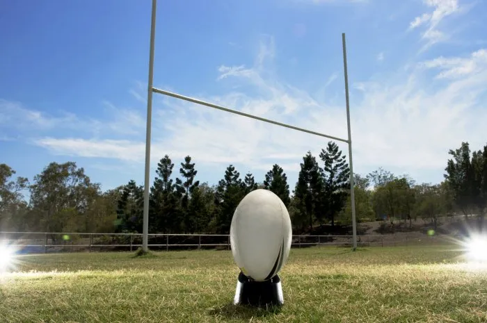 rugby football in front of goal posts, with lighting effects either side