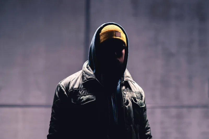 hooded criminal in dark mystery man with hood gangster in urban street hooligan in hoodie stalker with hidden face unknown suspicious thief, burglar, hacker or terrorist with grunge background