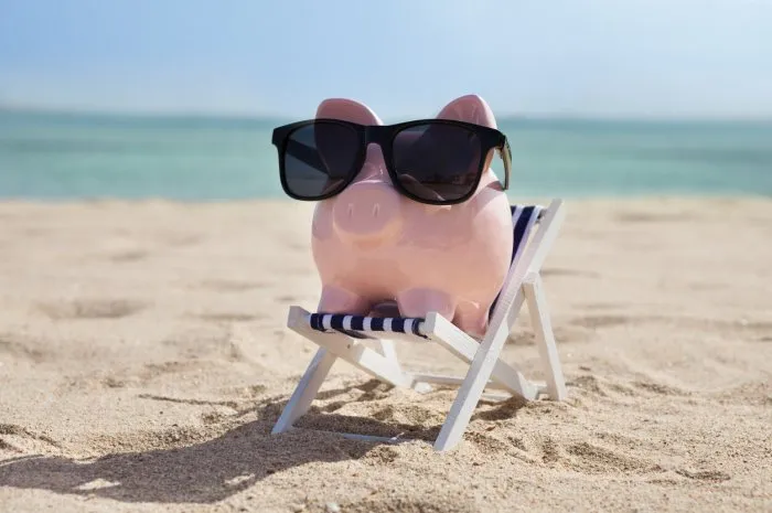 piggy bank on deckchair with sunglasses