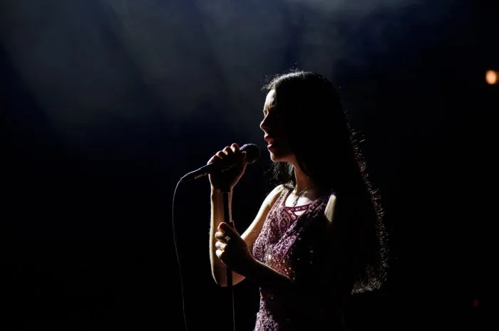 portrait of beautiful singing woman on dark background