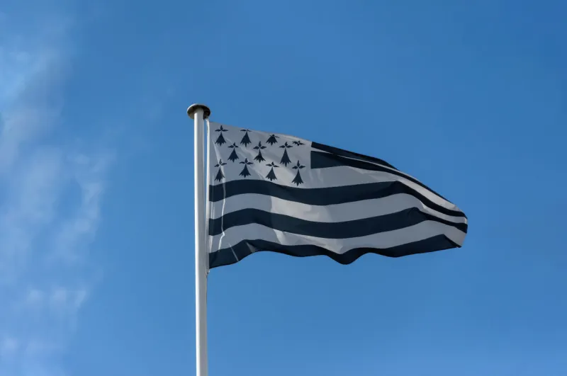 the flag of brittany 5 black stripes represent french or gallo speaking areas, 4 white stripes represent breton speaking areas symbols recall their coat of arms