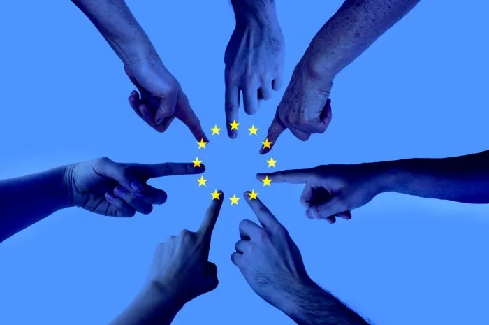 hands pointing on the same spot with an layered european union flag - agreement elections to the european parliament concept