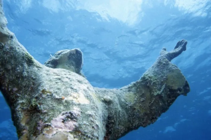 this is a close-up photo of the thirty foot statue in john pennekamp coral reef state park in florida of the christ in the abyss statue it is a replica of a statue that is in the mediterranean sea
