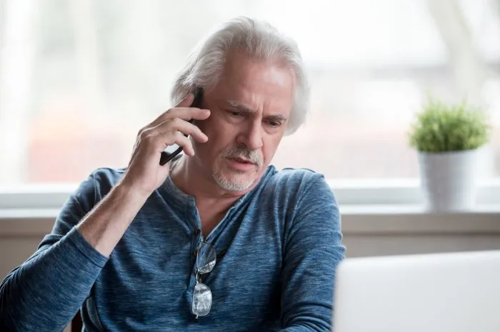 worried unsatisfied middle aged male sitting at home make business call solve issues distantly communicating use gadget customer having difficulties telling about laptop problems to service support
