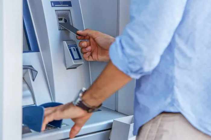 man using a street atm machine and withdrawing money, close up photo