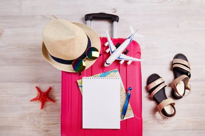 a suitcase with things and accessories for a vacation summer travel, preparation for the trip, packing of luggage travel checklist concept