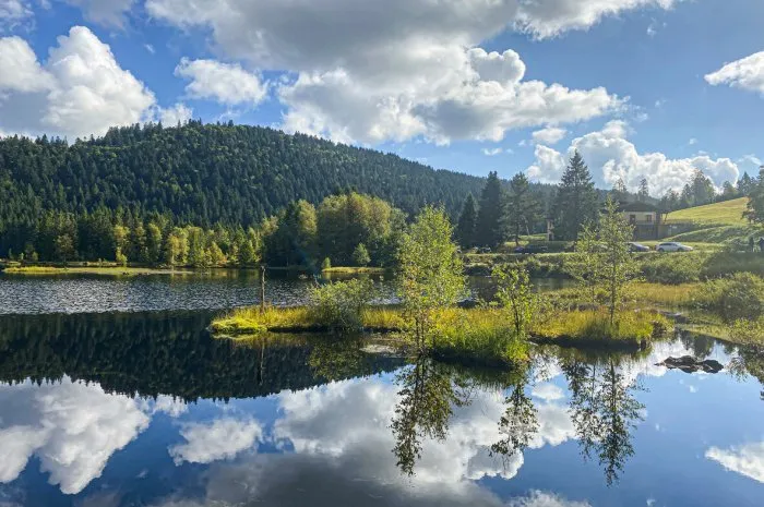 beautiful clouds reflection in water of lispach lake in the la bresse, vosges