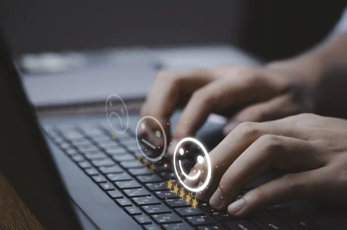 customer satisfaction survey concept, businessman using computer laptop select smiley face icon with yellow five stars to evaluate product and service