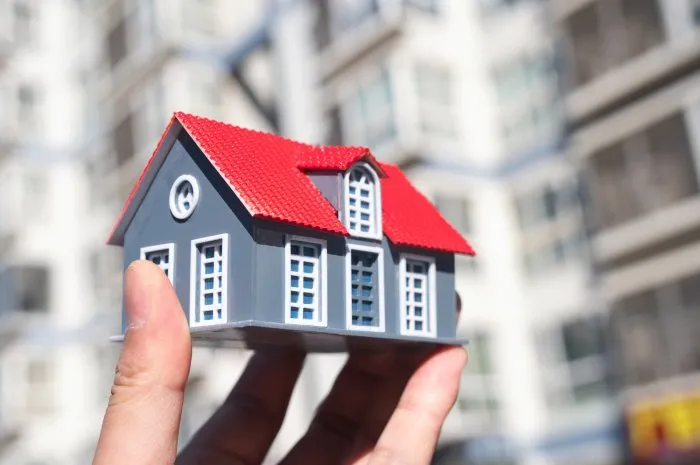 model of small house in front of residential building