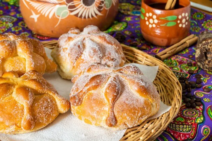 traditional mexican bread of the dead (pan de muerto) served with coffee from the pot (cafe de olla), this bread is made around the day of the dead celebration and is often left on altars of remembrance