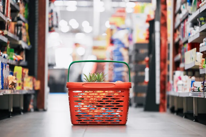 supermarket, shopping and store grocery basket on floor of retail food shop for eating, drinking and health pineapple, apple and fruit product sale at mall food market for a customer or consumer