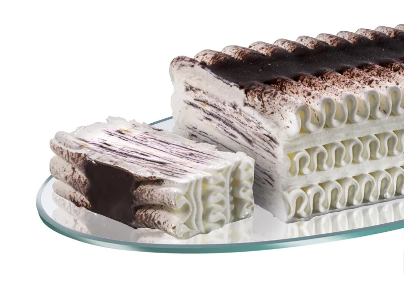 viennetta-type ice cream cake, whipped cream with cocoa and chocolate flakes, sliced on a glass tray