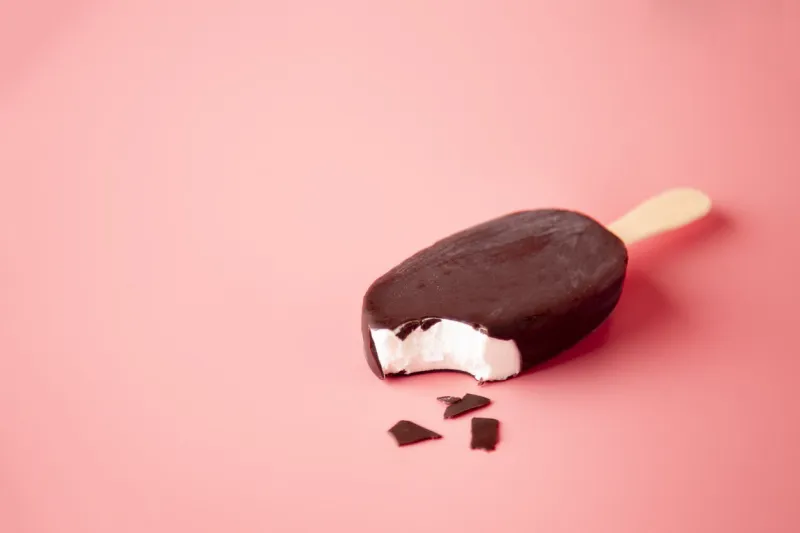 chocolate ice cream bite and crumbled on a pink background summer food concept creative summer concept flat lay