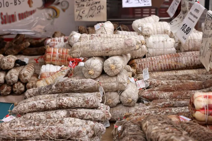 cremona, italy - september 7, 2022  traditional meat products sold at a street stall during the farmers market in cremona, lombardy, italy