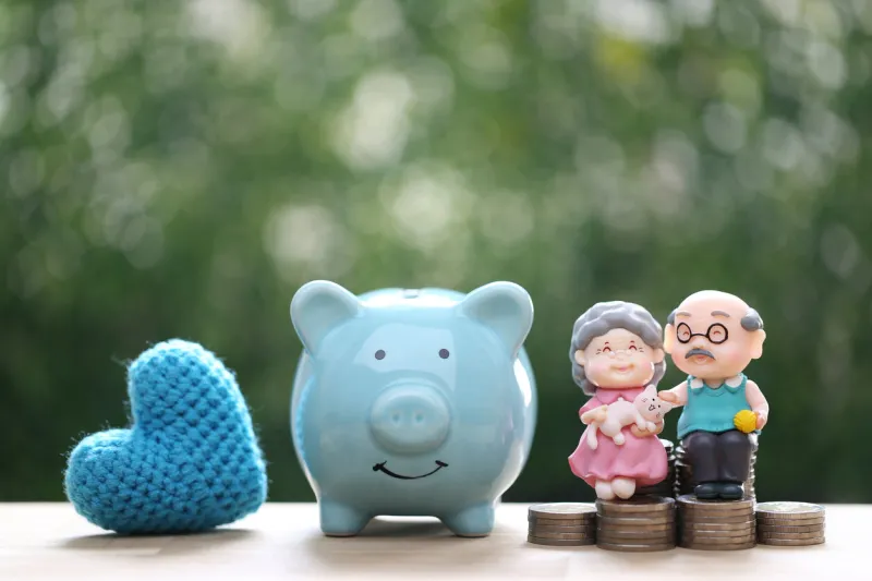 love couple senior and piggy bank on natural green background, save money for prepare in future and pension retirement concept