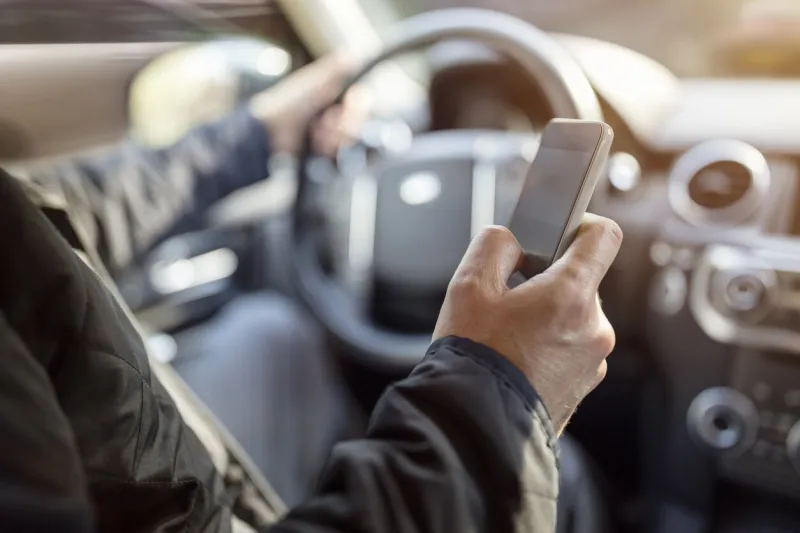 using a phone in a car texting while driving concept for danger of text message and being distracted