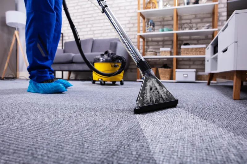 human cleaning carpet in the living room using vacuum cleaner at home