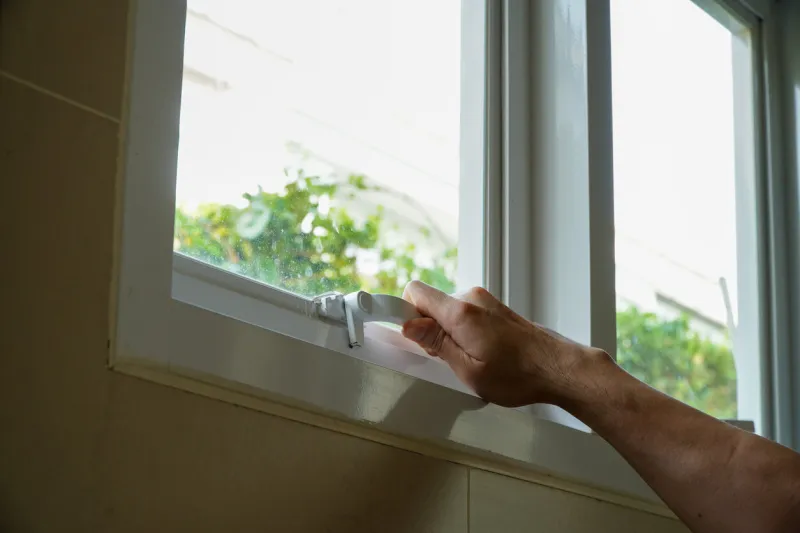 handsome male hand opening ventilation window in gray house with aluminum filter,energy saving concept