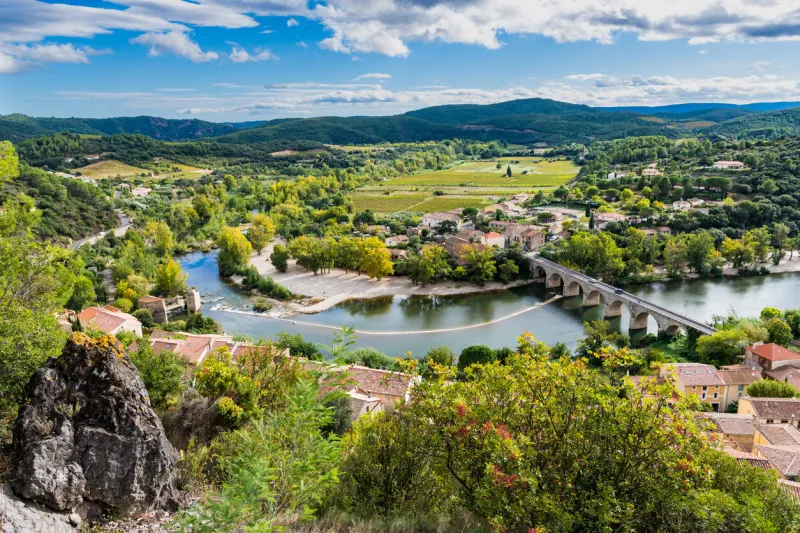 landscape of the orb river valley and arched bridge from the village of roquebrun, france