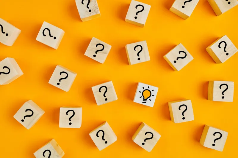 concept of to find a creative idea or problem solving question mark and light bulb icons on wooden cubes on yellow background