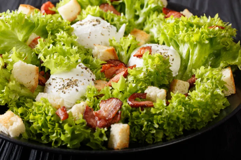 french salad lyonnaise with lettuce, croutons and eggs poached macro on a plate horizontal