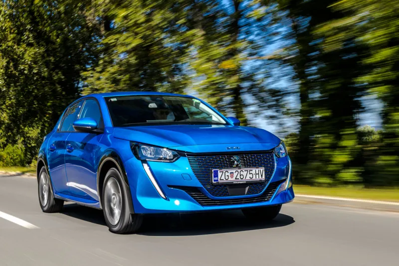 zagreb, croatia - september 8, 2020  man is driving fully electric car peugeot e-208 fast on a road it's the first fully electric car that look like an ordinary model