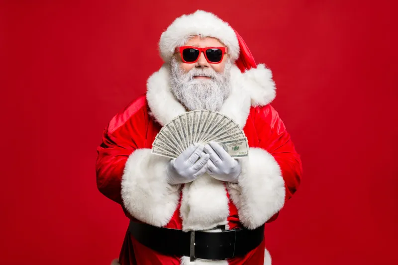 portrait of cool stylish elderly santa claus hipster millionaire have cash, want buy presents spend on winter season sales discount wear cap hat eyewear eyeglasses isolated over red background