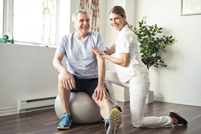 a modern rehabilitation physiotherapy worker with senior client