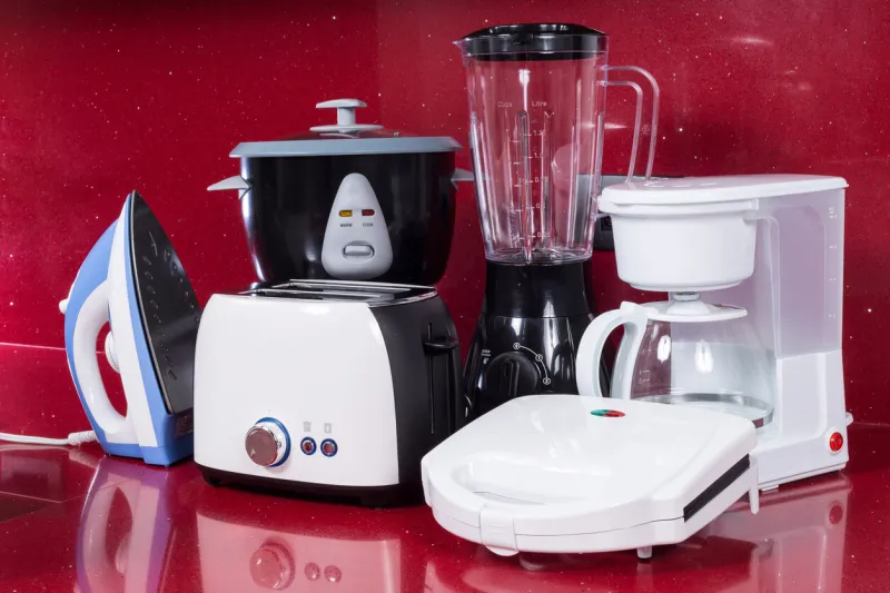 household appliances in modern kitchen red background