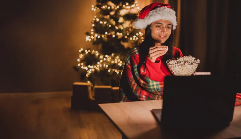 cute lady wear red pullover watching modern device christmas movie eating popcorn indoors home room copy space