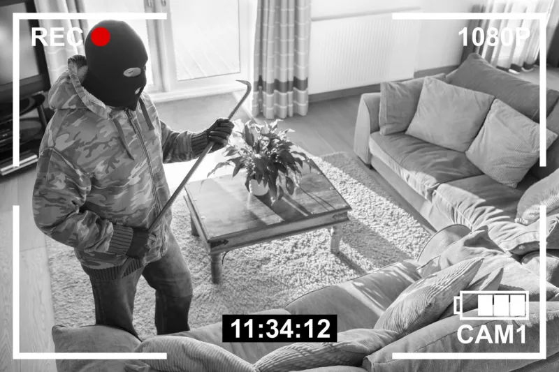 cctv surveillance security camera of burglar breaking into home via back door window with crowbar house robbery concept