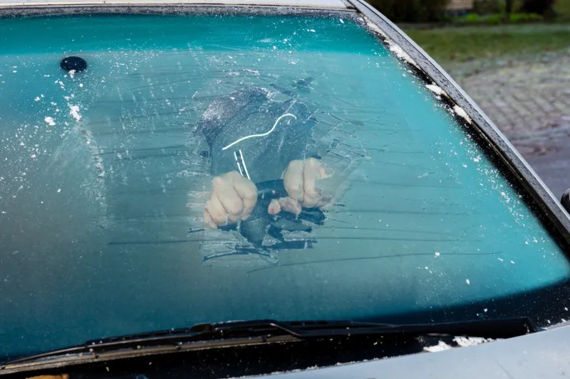 removing ice from the frozen windshield