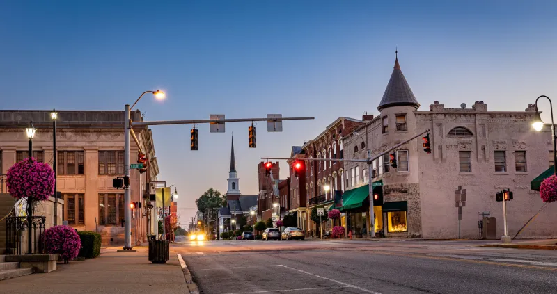 street lights and traffic lights shining during early morning hours on mid west city street