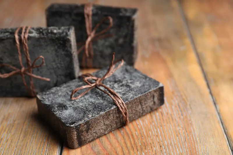 natural tar soap on wooden table, closeup