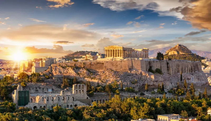 the acropolis of athens, greece, with the parthenon temple on top of the hill during a summer sunset