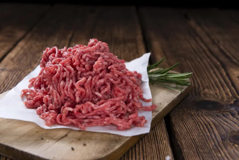 minced meat (close-up shot) on vintage wooden background
