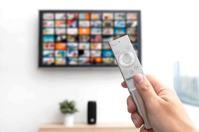 multimedia video streaming concept television set, remote control in hand