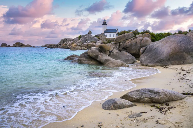 the pontusval lighthouse, located on a rocky point in northern finistere in brittany, overlooks a sea of transparent turquoise waters during sunrise