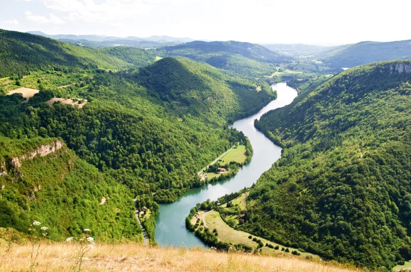 a winding river passing through gorges between green hills