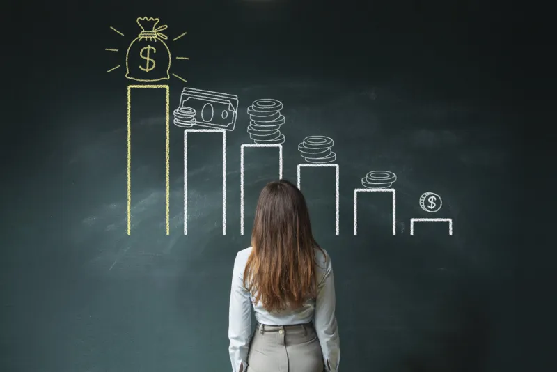 business woman standing in front of a blackboard with a financial chart