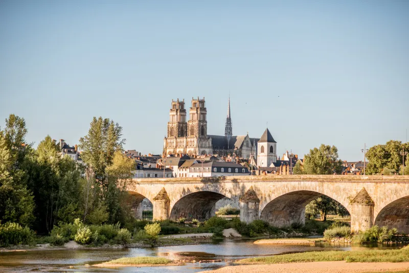 landscape view on the river and old arch bridge in orleans city during the sunset in france