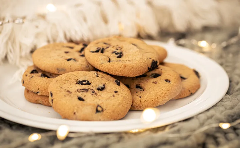 close-up of chocolate chip cookies on a plate on a blurred background with a garland