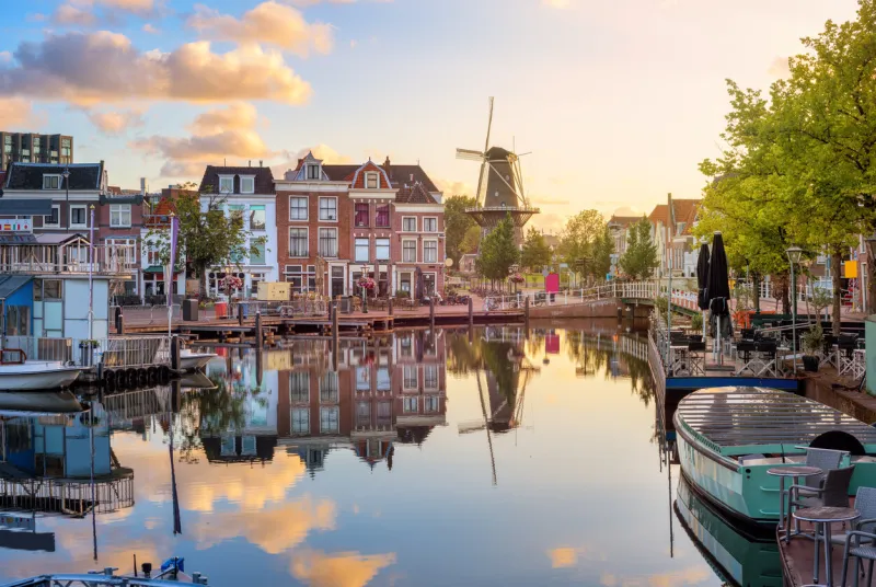 leiden old town cityscape, view of the beestenmarkt and the de valk mill reflecting in rhine river on sunrise, south holland, netherlands
