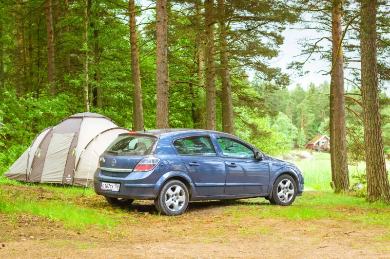 hamina, finland - june 13, 2014  summer outdoor recreation, scandinavian vacation car opel astra h parked in a wooded campsite among pine trees finnish gulf area for camp in woods hamina, finland, suomi