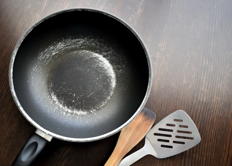 old scratched non-stick saucepan on the table
