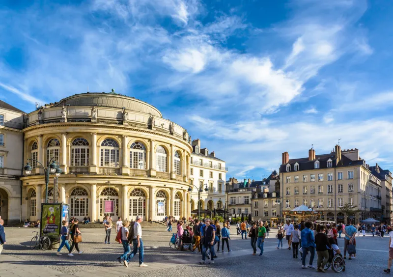 rennes, france - october 13, 2018  people strolling on the pedestrian town hall square in front of the rounded facade of the opera house by a sunny saturday afternoon under a deep blue sky